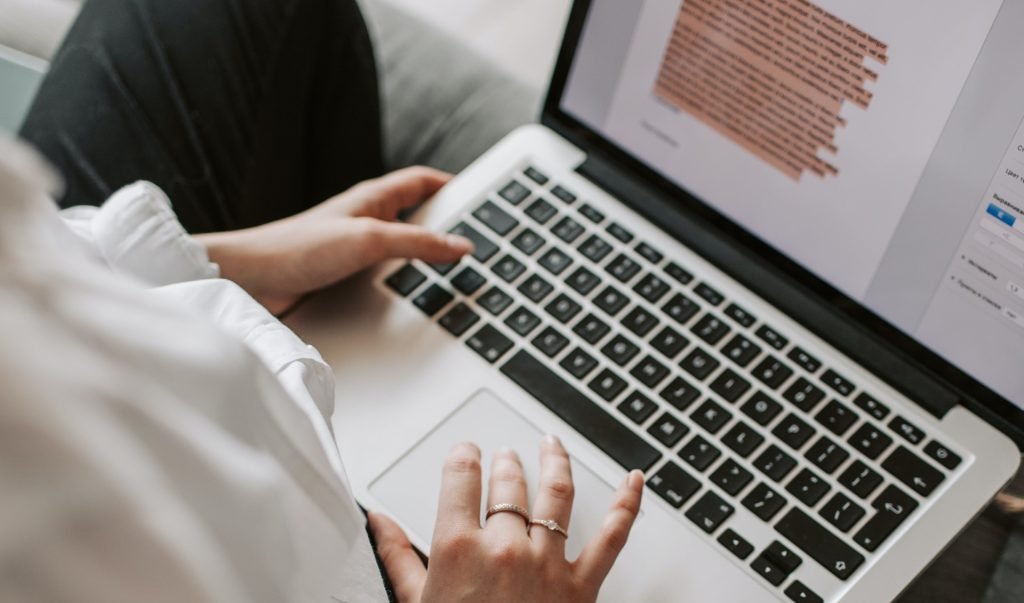 woman typing on a macbook